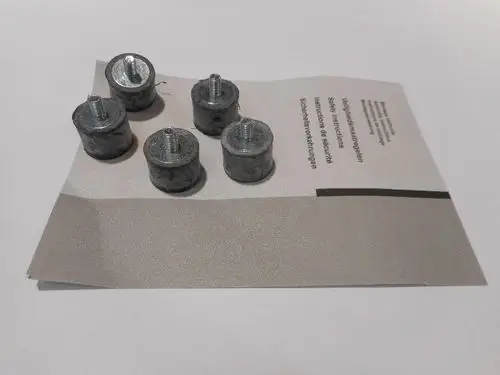 Sechs Metallunterlegscheiben auf einem Papier mit Anweisungen, das einen Teil der Produktinformationen von Remeha enthält.